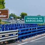 Rodovia com veículos em movimento e placas de direção na região de Barcelona, na Espanha.