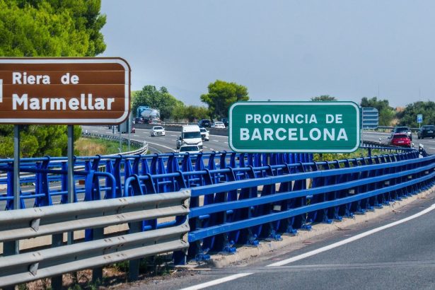 Rodovia com veículos em movimento e placas de direção na região de Barcelona, na Espanha.