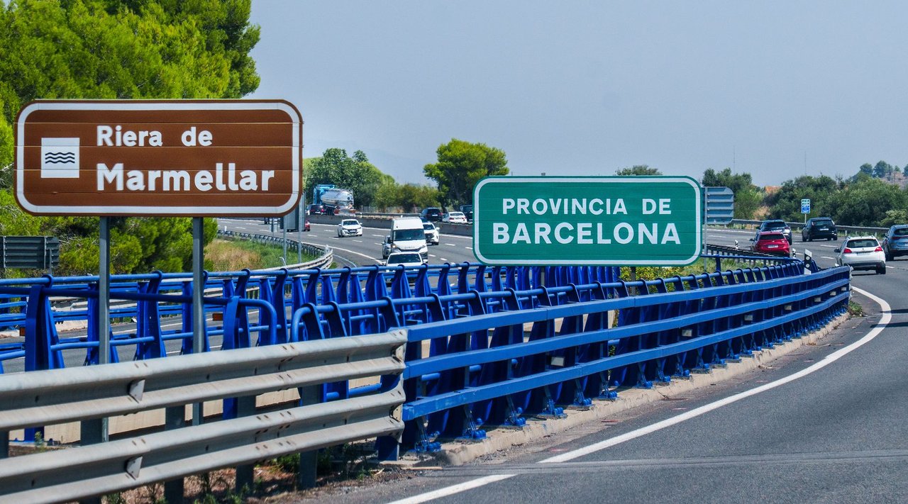 Rodovia com veículos em movimento e placas de direção na região de Barcelona, na Espanha.