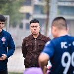 Jogadores de futebol reunidos em campo durante uma conversa sobre a estratégia da equipe.